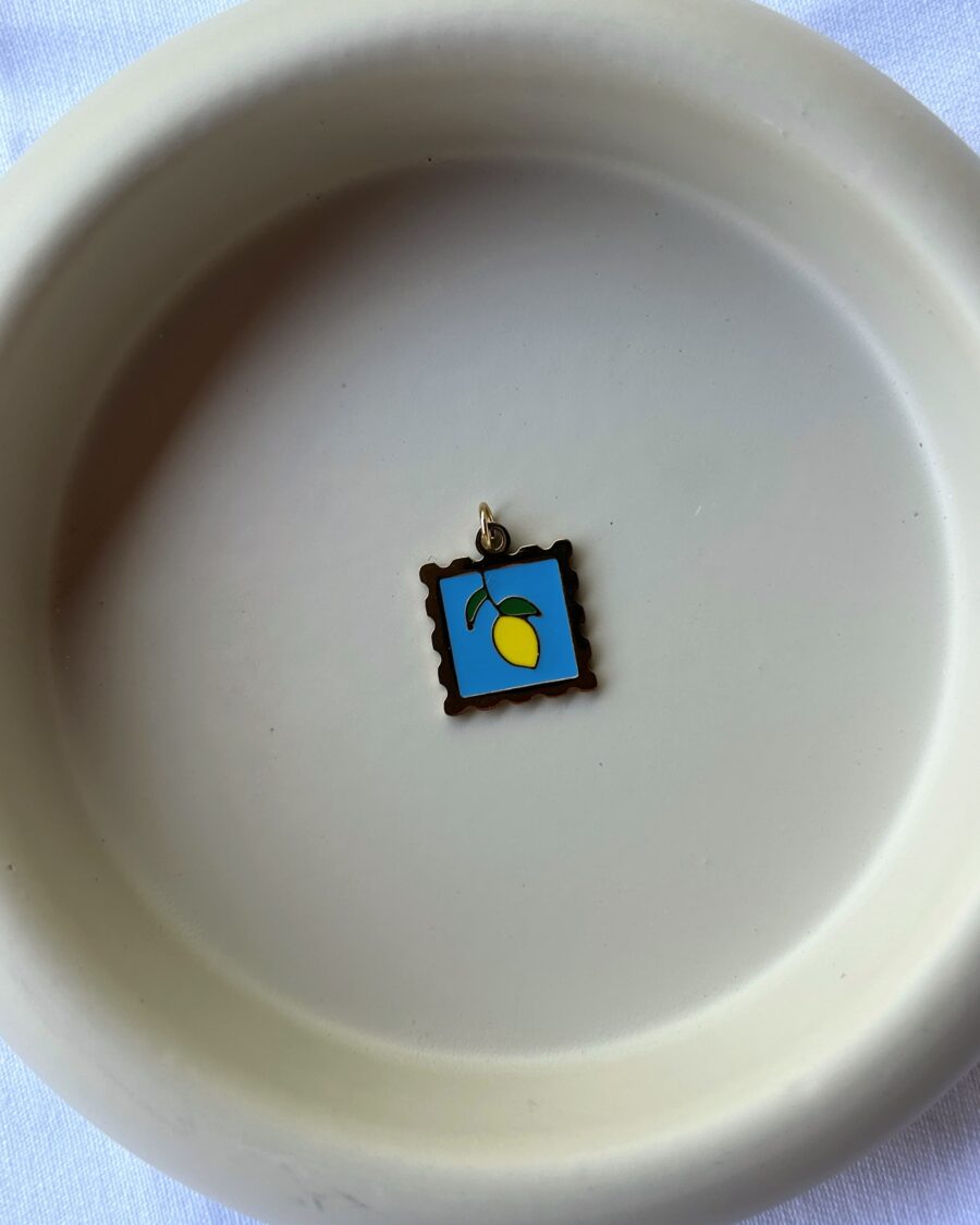 zitronencharm als goldene briefmarke auf grauem hintergrund