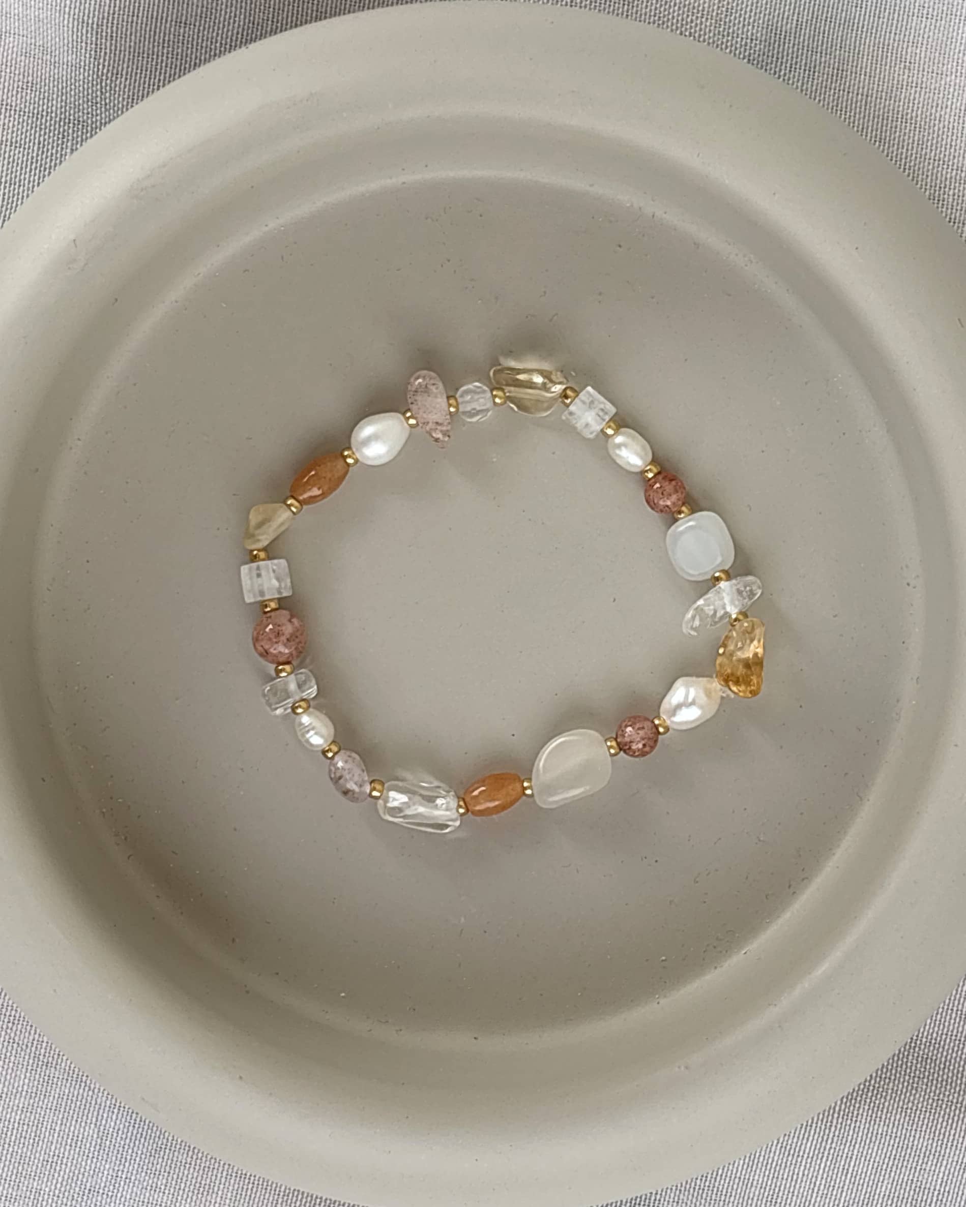 braun beiges armband auf grauem hintergrund