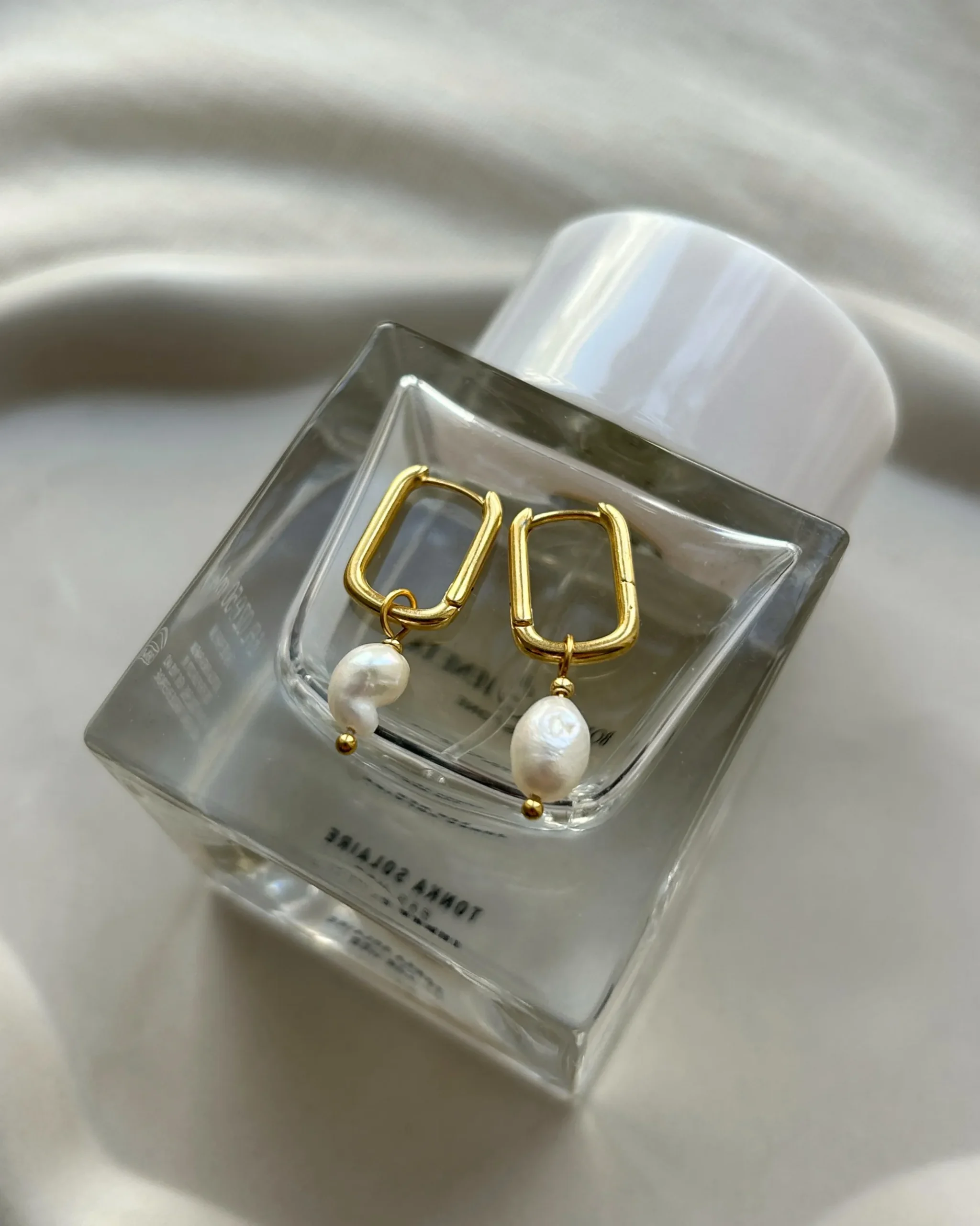 Ohrringe liegen auf parfum