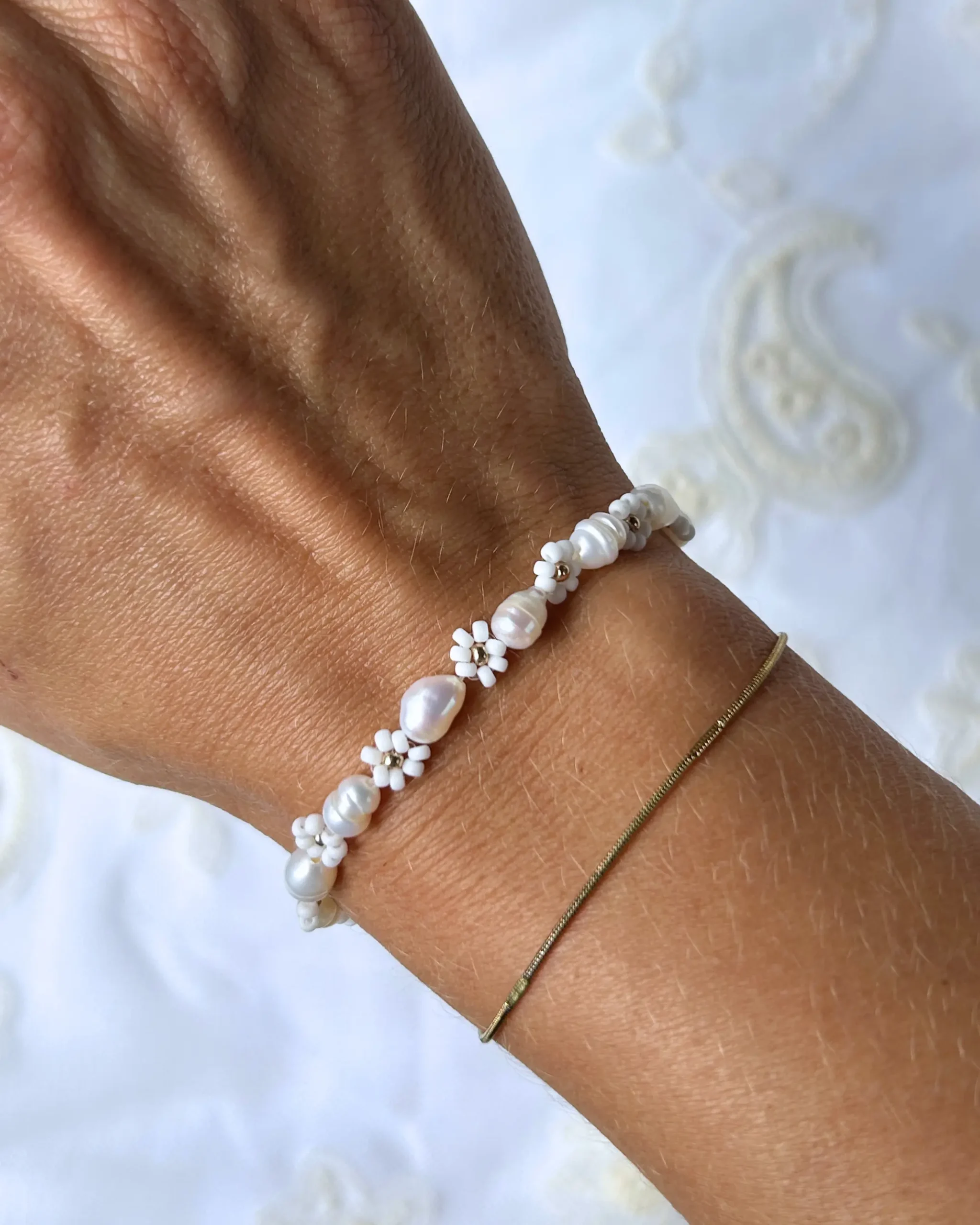 weißes blumenarmband am Handgelenk